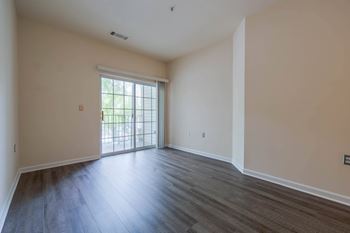 A room with a sliding glass door leading to a balcony.
